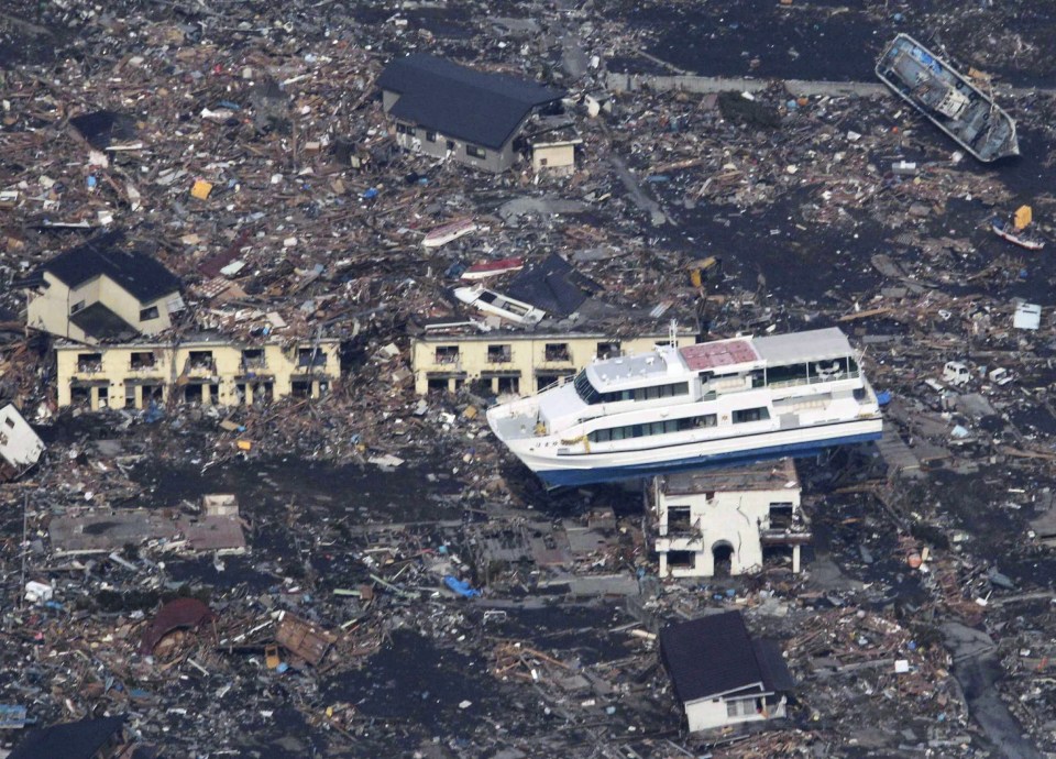 A ferry is perched on top of a house in the aftermath of an earthquake and tsunami in Otsuchi