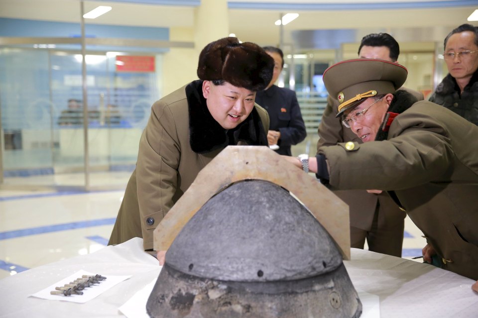  North Korean leader Kim Jong Un eagerly looks at a rocket warhead tip after a simulated test of atmospheric re-entry of a ballistic missile