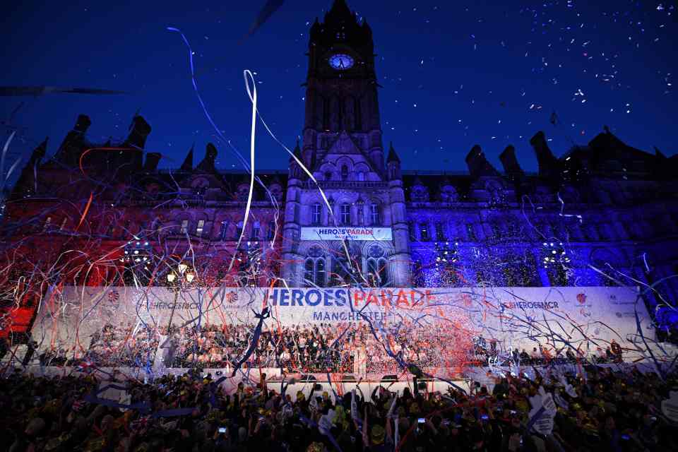 Members of the British Olympic and Paralympic teams are applauded by the general public on a stage in front of Manchester Town Hall