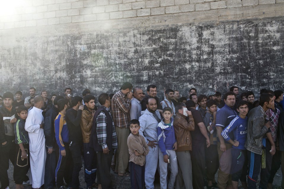  People queue up to get an aid packages in Gogjali after it is free by Iraqi troops