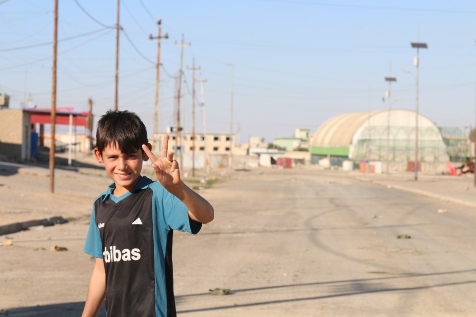  A boy gives the peace sign to the liberating troops