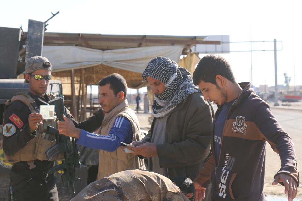  Soldiers check the IDs of anyone who wanders near their makeshift base