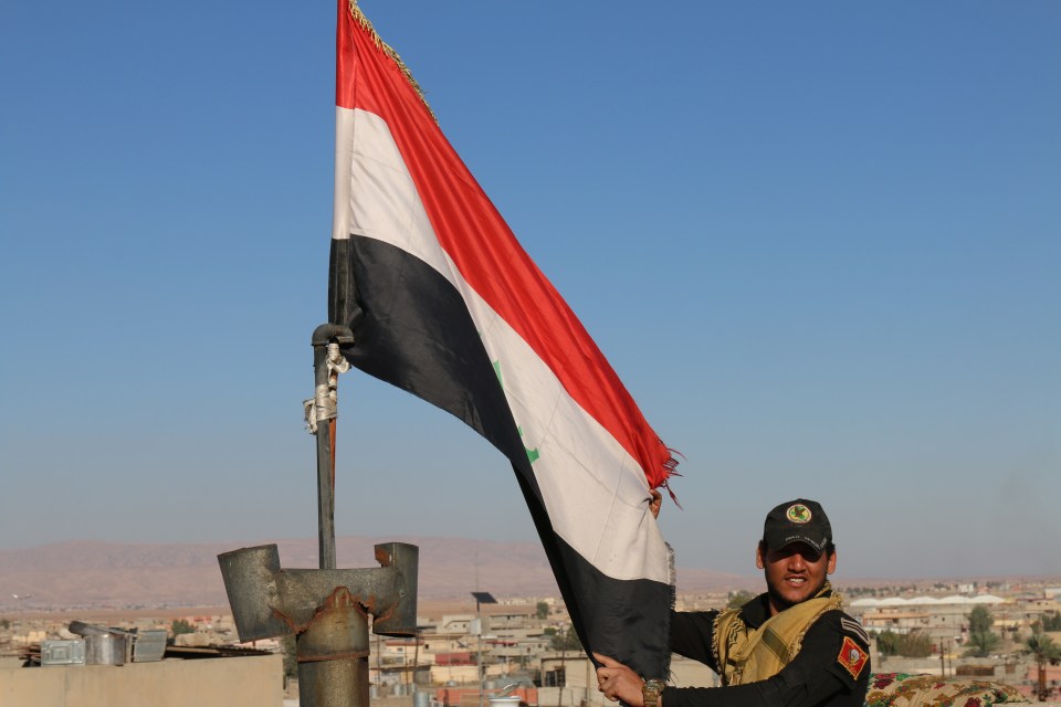  An elite Iraqi special forces soldiers erects the national flag over the newly-won suburb