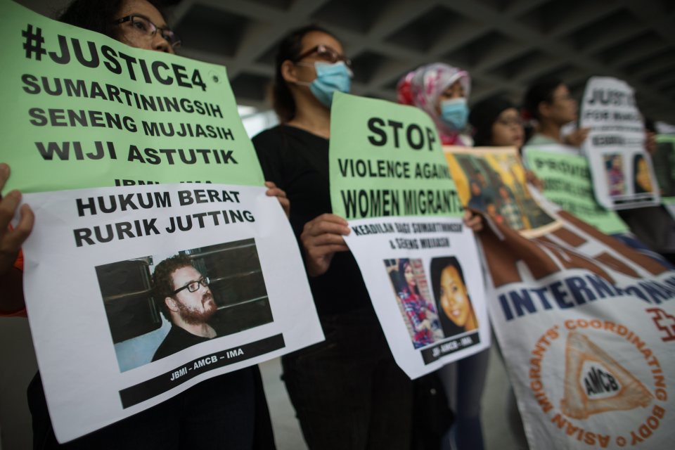  Indonesian migrant workers hold placards during a protest outside the High Court in support of murdered Indonesian nationals