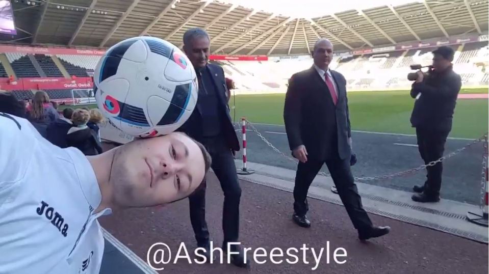  Freestyler Ash Randall balances the ball on his head as Jose Mourinho approaches