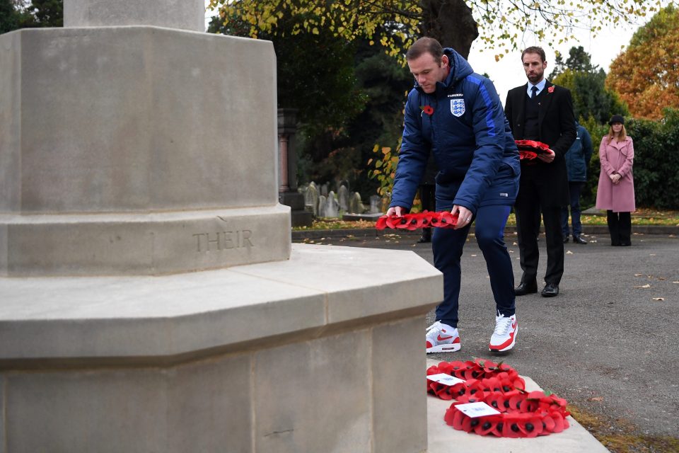 Wayne Rooney lays a poppy wreath at the foot of a war memorial