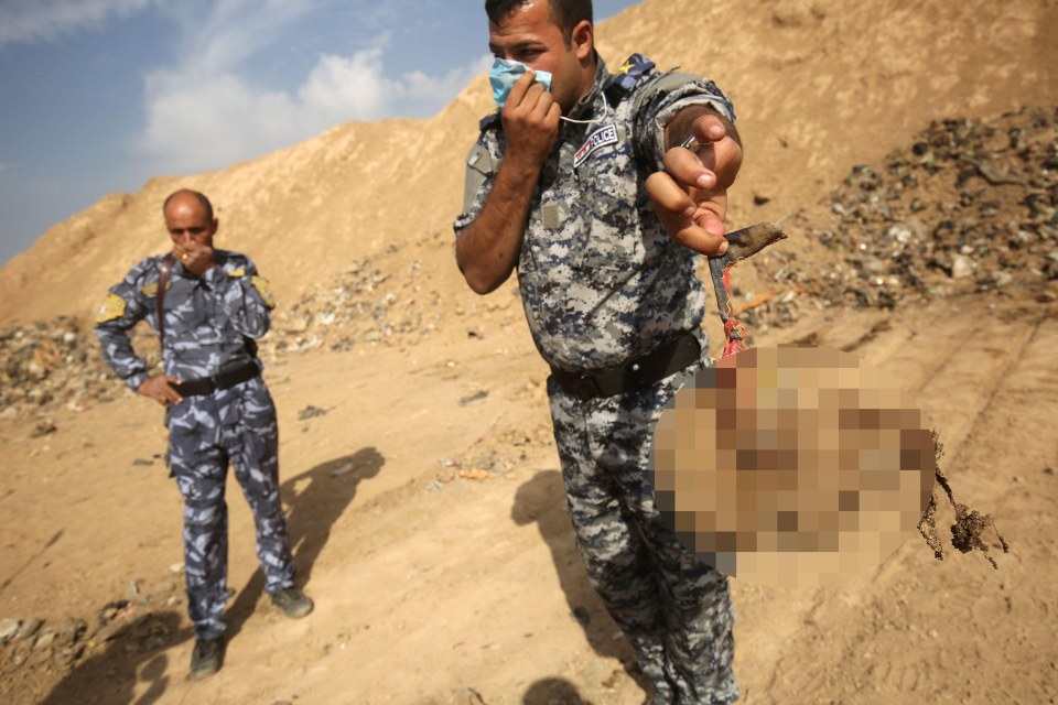  An Iraqi soldier holds a head of an alleged ISIS genocide victim