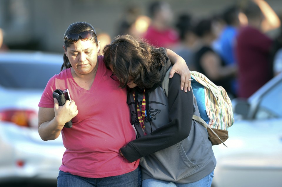  Buildings were put into lockdown following the shooting - a mother is seen here picking up her daughter