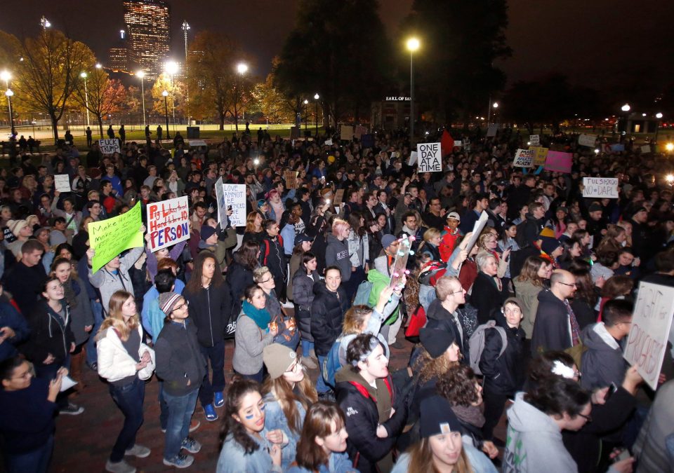  Protesters hold signs in opposition to the election of Republican Donald Trump in Boston, Massachusetts