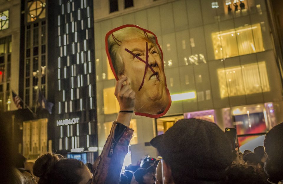  Trump depicted as the devil ... numerous protesters took to the streets with offensive placards, with other signs reading 'Donald Trump is a racist' and 'undocumented and here to stay!'