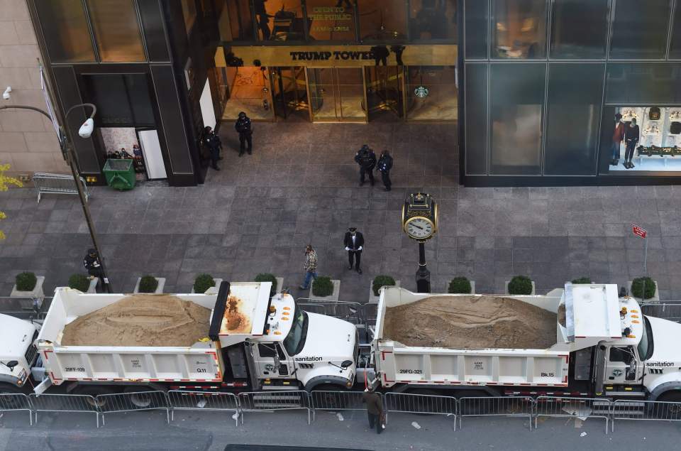 A protective barrier of Sanitation Department trucks parked in front of Trump Tower to provide security to US President-elect