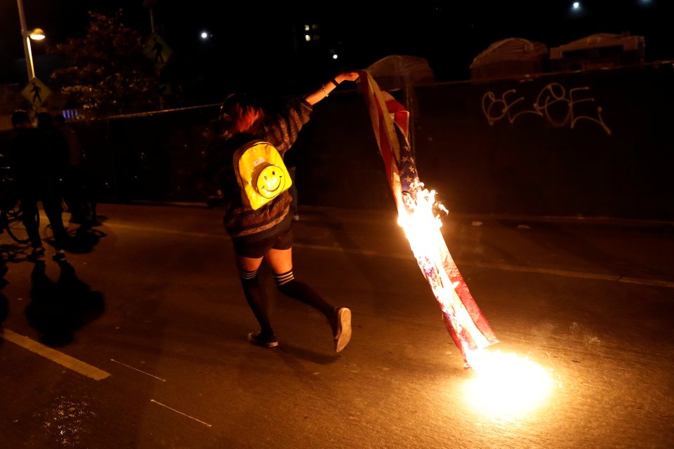  A demonstrator runs while holding a burning flag