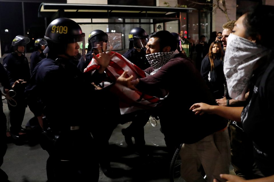  A masked demonstrator scuffles with police officers during the trouble in Oakland,