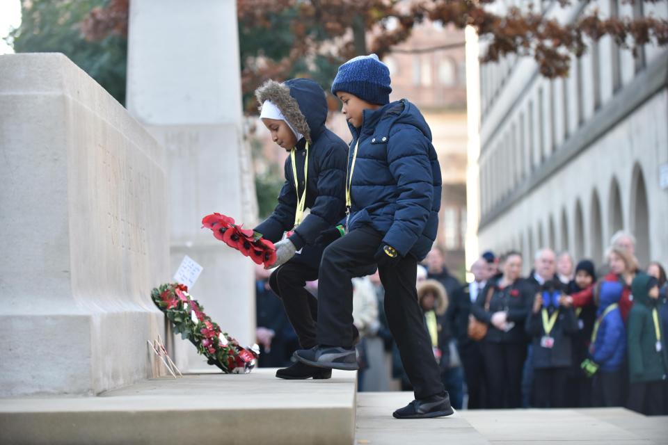  Two young children lay a wreath at the cenotaph in Manchester