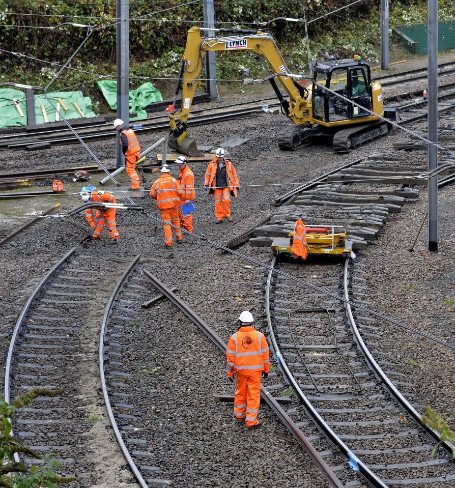  Rail workers at the site work to fix the track where the tram derailed on Wednesday