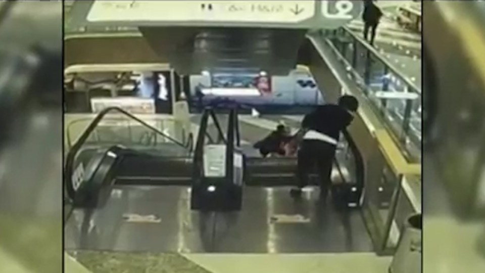  The mother can be seen charging down the escalator while shocked staff look down at the horror scene