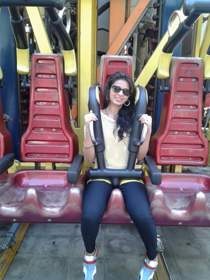 Smiling Young Woman Enjoying Amusement Park Ride