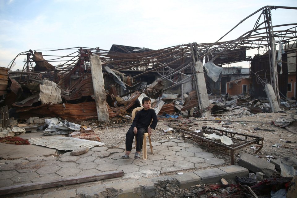  A boy sits amid the damage at a site hit yesterday by airstrikes in the rebel held besieged Douma neighbourhood of Damascus, Syria