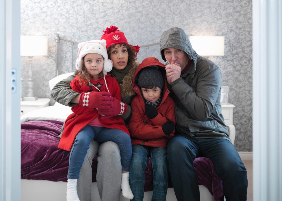 Family wearing winter clothing in bedroom of energy efficient house