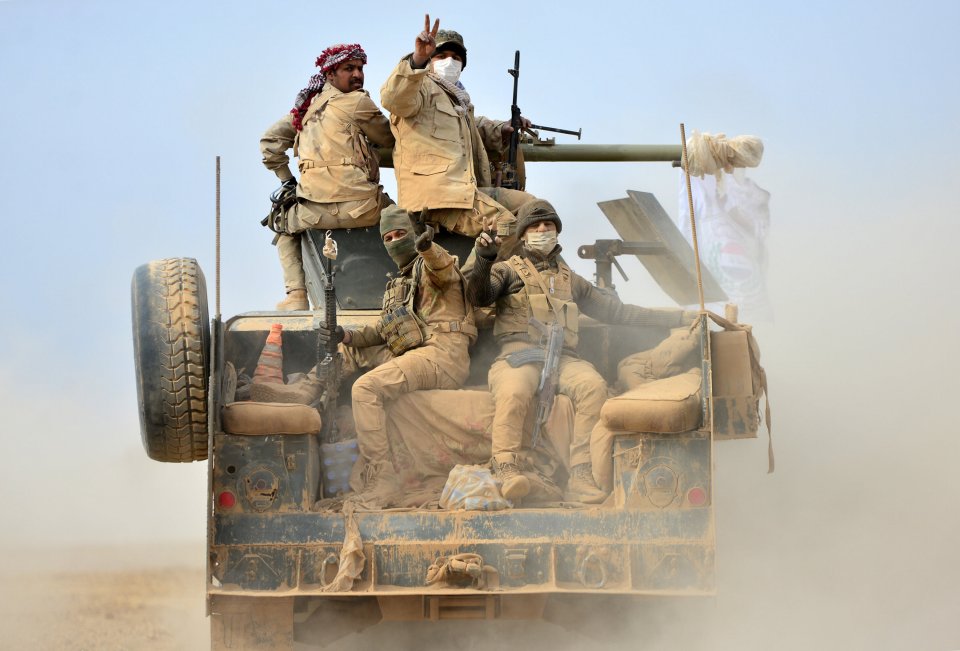  Shi'ite fighters ride on a military vehicle heading toward the airport of Tal Afar