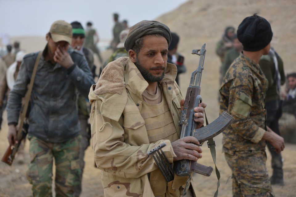  Shi'ite fighters carry weapons during a battle with ISIS militants in Tal Afar