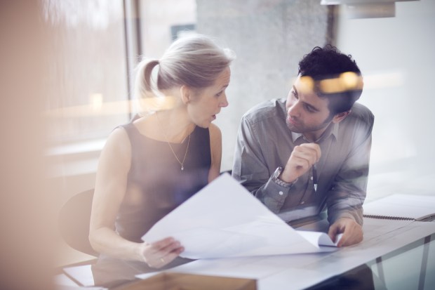 a man and a woman are looking at a piece of paper