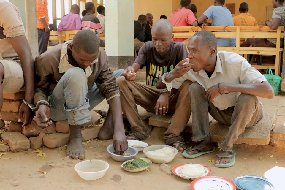  Aniva (right) eats with his co-defendants in the courtyard of the court in August