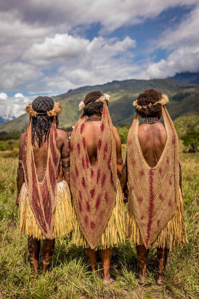 Women from the Dani tribe look across the hills in Western New Guinea