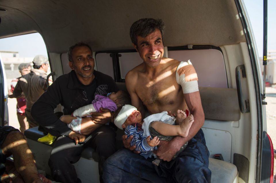  Mosul residents Hassan (R) and his brother Nakthel (L) hold their children