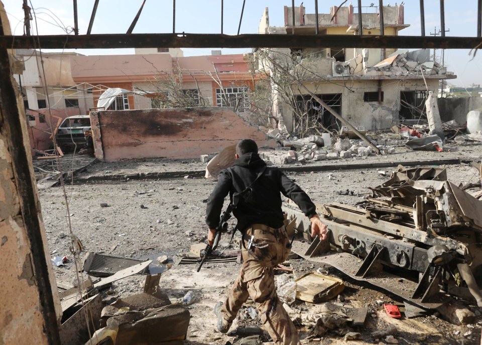  An Iraqi special forces soldier runs across a street in Mosul