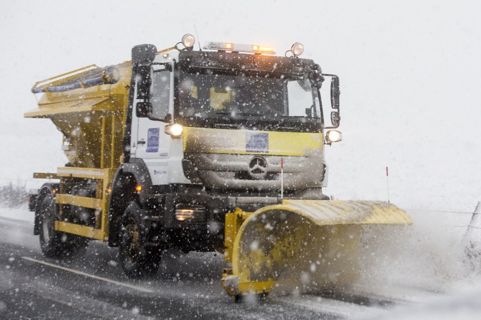  A gritting truck fitted with a snowplough steams down a road in Ingleton, Yorks., clearing the way for motorists