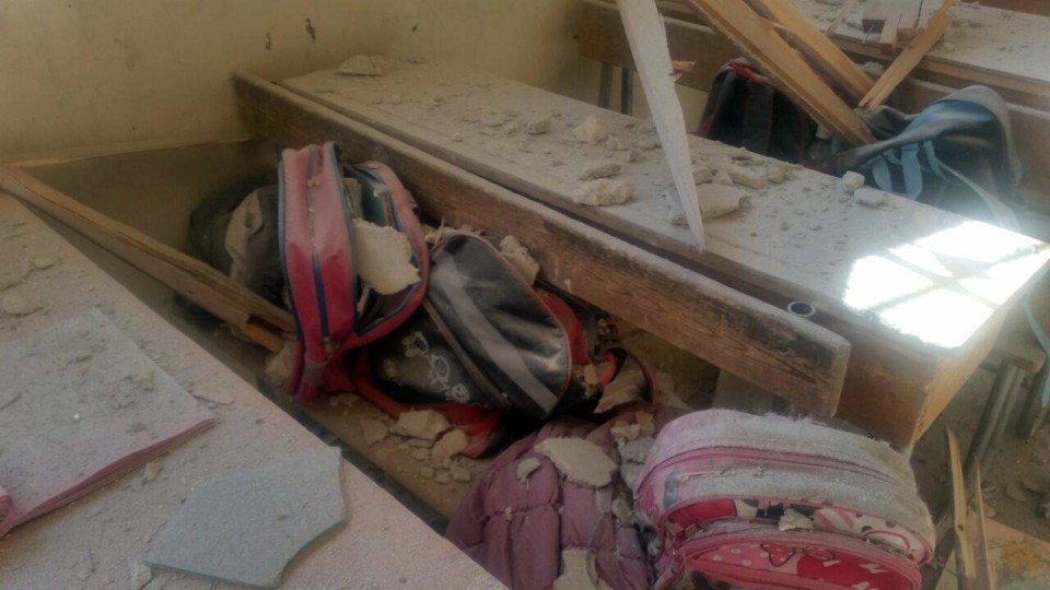  Students' bags are seen amid the debris of a damaged classroom after shelling