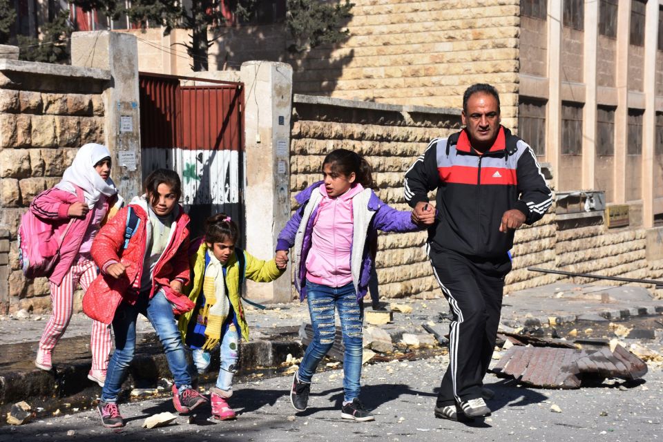  A man evacuates children from the school after it was hit by rebels