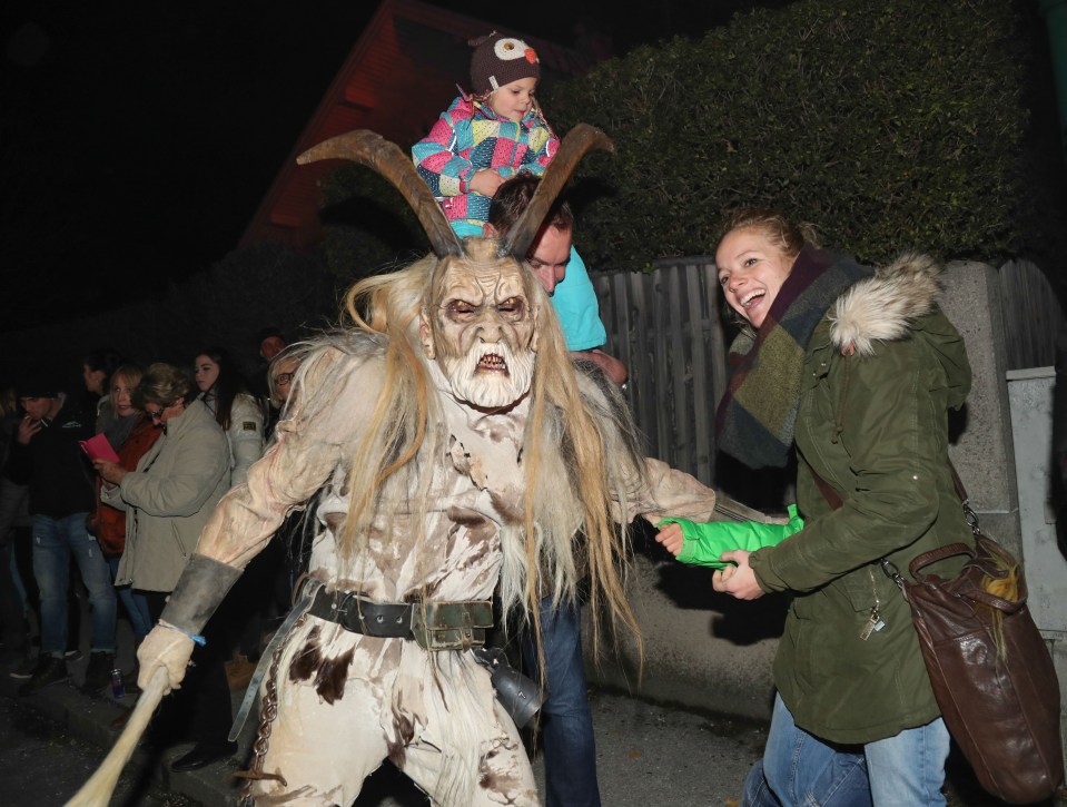 Some children don't seem too fazed by the terrifying beast as they pose with performers