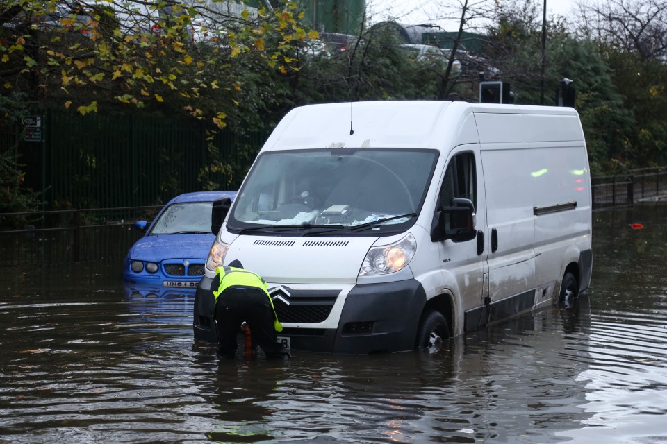 A man tries to free his van after getting stuck on a flooded road in Rotherham, South Yorkshire