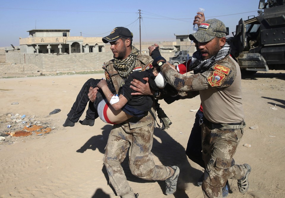  An Iraqi special forces soldier from the medical unit carries an injured boy