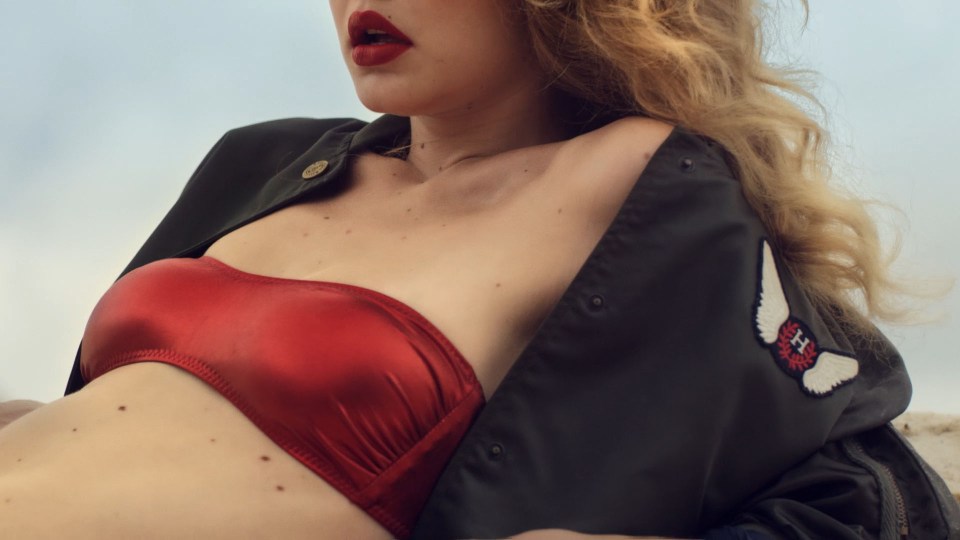  Gigi wears a red bandeau top with red lips