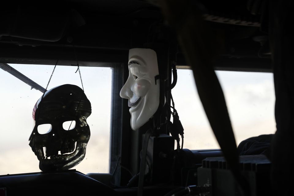  A mask of Guy Fawkes and another of a skull hang inside an Iraqi Special Forces armoured vehicle