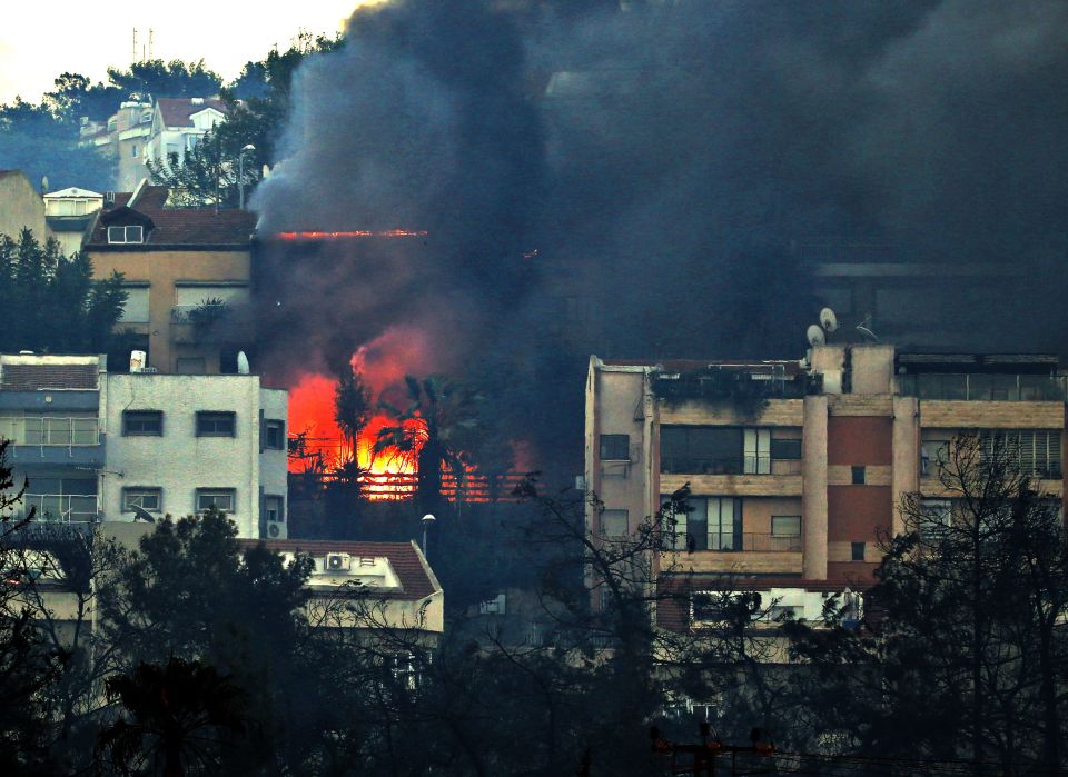  Smoke billows from a house in Haifa as uncontrollable fire rages on in Israel's third biggest city