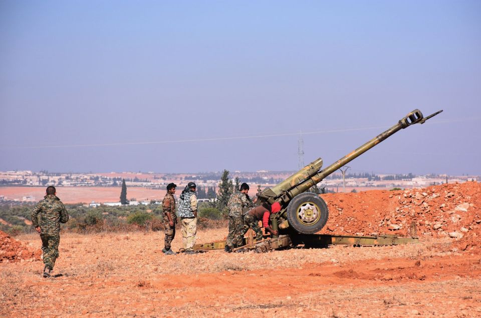  Syrian pro-government fighters fire a Russian 122mm howitzer gun