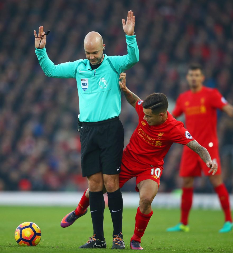  Referee Anthony Taylor is tackled by Philippe Coutinho as he gets too close to the action