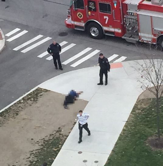  Police stand near a body at the scene of the shooting