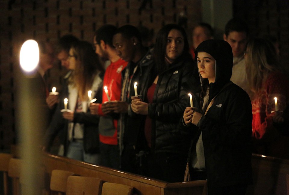  Mourners stand for a moment after lighting their candles during a vigil at St. Stephen's Episcopal Church in Columbus, Ohio