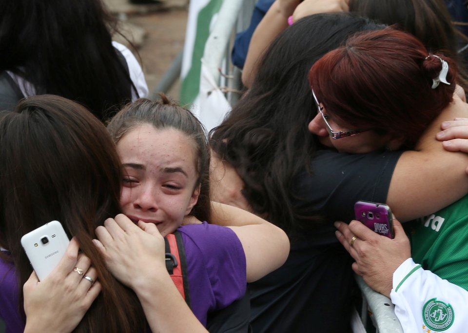 Supporters draped in the team's green colours embrace outside the ground