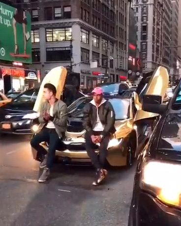 The video shows Coby Persin and one of his friends lounging on the flashy sports car as busy traffic crawls past them