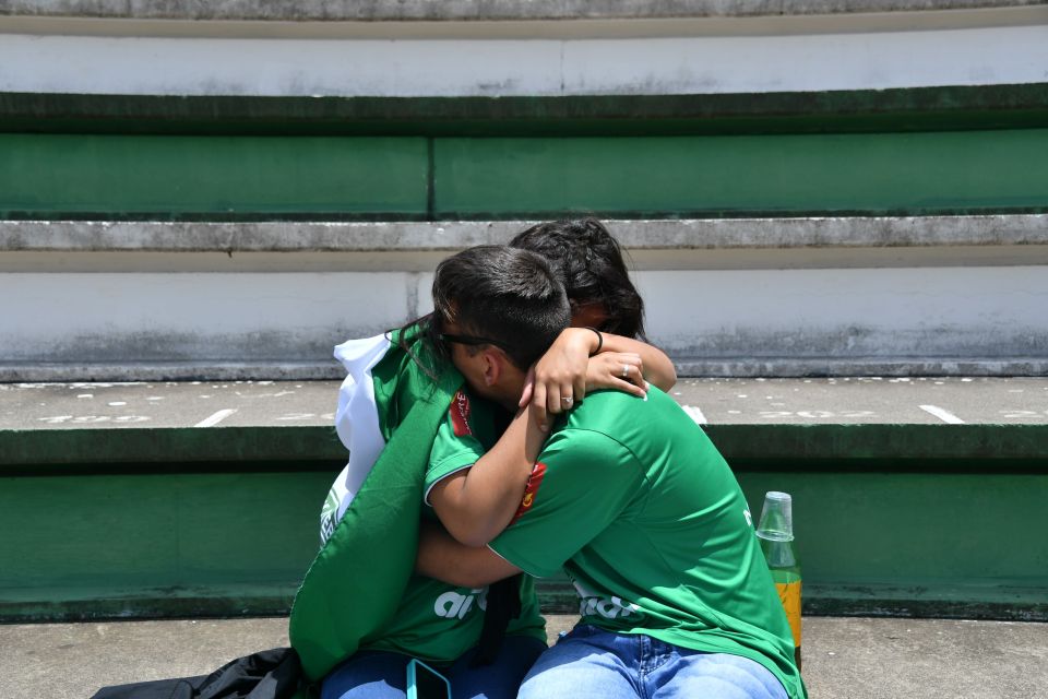 Two supporters cry during a tribute to their team