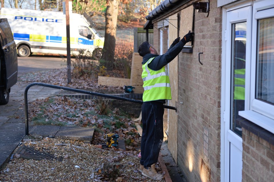  Workmen board up the house where the former coach had been living