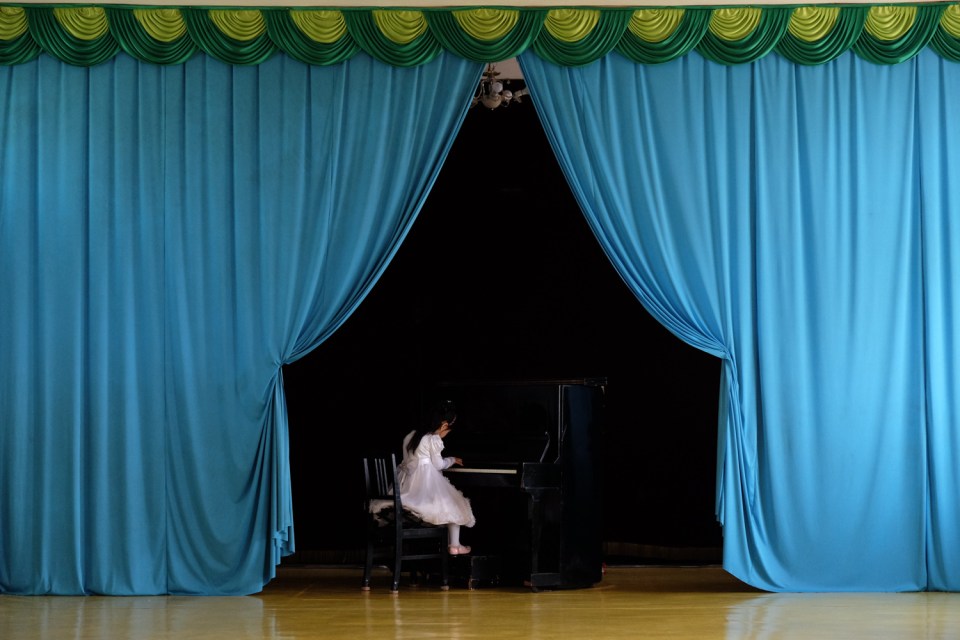  Young girl playing piano during a kindergarten performance in Chongjin