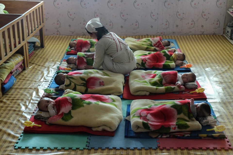  A nurse attends to young children in an orphanage near Nampo