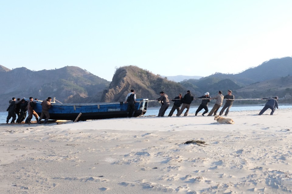  Villagers haul a boat over wooden rollers in outer Chilbo